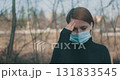 worried woman with mask in nature 131833545