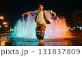 Dancing in front of the fountain in the park at night 131837809