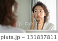 A woman who looks in the mirror and suffers from rough skin 131837811