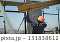 Construction worker installing beam on building site 131838612