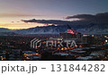 View of the large city at twilight with american flag waving in the wind and the high mountain. 131844282