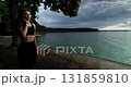 A Contemplative Woman Sitting by the Serene Lake, Enjoying the Beautiful Natural Surroundings 131859810