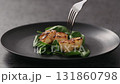 Slow motion eating roasted scallops with spinach in black plate 131860798