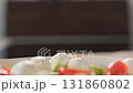 Slow motion slide shot of man pour olive oil over salad in bowl 131860802