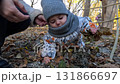 Baby Crawling on Autumn Leaves at Playground 131866697