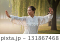 Asian woman practicing tai chi or qigong exercise in park with morning sunlight background 131867468