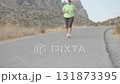Overweight Woman Running on Mountain Road in Evening Light Training for Weight Loss and Healthy Lifestyle 131873395