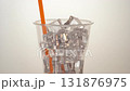 Thai iced tea is slowly poured into clear plastic cups and orange straws filled with sparkling ice cubes. As the Thai tea flows slowly and the sound of the ice gently hitting each other creates a refr 131876975