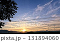 View of the summer sunset sky and silhouettes of trees and mountains seen while driving the countryside roads, showing a candid peaceful rural lifestyle 131894060