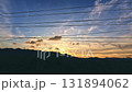 Silhouetted mountains under a colorful sky with power lines at sunset seen while driving creating a calm and soothing moment 131894062