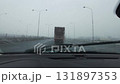 Cleaning car windshield with wipers during rainy foggy drive on highway 131897353