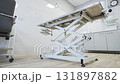 Adjustable examination table stands in therapy room 131897882