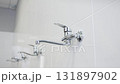 Row of glossy metal faucets shines under bright light 131897902
