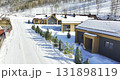 Cozy cabins clearly outlined against snowy wooded mountains 131898119