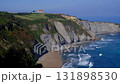 A breathtaking wide shot of the rugged coastline in Gijon, Asturias, Spain, featuring steep, layered cliffs covered with rich greenery 131898530