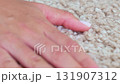 a woman's hand touching the beige Interior pile carpet made of polypropylene.  131907312