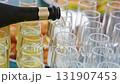Champagne from the bottle is poured into glasses.  131907453