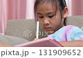 Close-up of an Asian child playing a mobile game on smartphone at home, showing modern lifestyle, technology use, and digital entertainment among kids today. 131909652