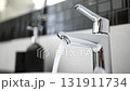 Female Hand Opens The Mixer Tap Of The Bathroom Sink. Water Flows From The Faucet 131911734