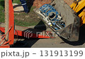 Yellow excavator loader bucket with drilling equipment on asphalt, close-up. Concept of works in drilling and water supply system, service 131913199