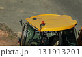Orange beacon flashing on yellow roof of tractor loader, industry. Copy space for text, renovation work 131913201