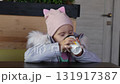 Little girls drinking cocoa in a cafe 131917387