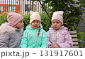 Little triplet sisters kissing on a bench 131917601