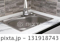 A woman's hands wash a metal pan in the sink 131918743