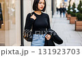 ショッピング街の通りを背景に、クールな表情でボブヘアの女性 131923703