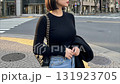 街の横断歩道を背景に、クールな表情でたたずむボブヘアの女性 131923705