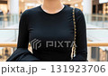 ショッピングモールを背景にした、黒い長袖Tシャツ姿の女性の上半身  キーワードの言語 : 日本語 131923706