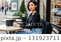 カフェのテラス席でコーヒーを片手に、こちらを見つめるボブヘアの女性 131923711