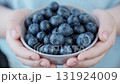 Girl holding bowl with fresh blueberries. Healthy eating concept. 131924009