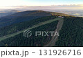 Stunning aerial footage showcasing a mountainous landscape, complete with ski lifts and lush forests. 131926716
