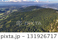 A stunning aerial capture showcases a breathtaking view of mountains, lush forests, and picturesque valleys below 131926717