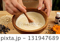 Natural ingredients like oats, lavender, and calendula are scattered on the wooden table, highlighting the use of organic components in this DIY soap making workshop 131947689