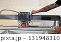 Construction Worker Using Tile Saw Cutting Machine for Home Improvement Project 131948310