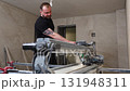 Construction Worker Using Tile Saw Cutting Machine for Home Improvement Project 131948311