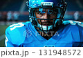 A focused athlete in a football helmet prepares for competition on the field, showcasing determination and skill during a high-stakes match. 131948572