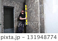 Construction worker using spirit level installing marble tile on wall 131948774