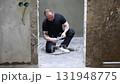 Construction worker placing travertine tiles in shower floor during bathroom renovation 131948775