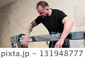Construction worker using tile saw cutting machine preparing ceramic tiles for bathroom renovation 131948777