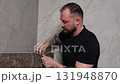 Construction worker installing tiles in a new modern bathroom 131948870