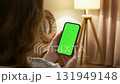 Woman sit use digital tech cell phone green screen mock up. Hand scroll phone tinder web site swipe, like right left. Girl hold mobile closeup. Chroma key page. Cozy background. Online app copy space 131949148