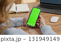 Woman sit use digital tech cell phone open green screen mock up. Hand scroll phone web site swipe unlock. Girl hold mobile closeup. Turn on chroma key page Cozy home background. Online app copy space 131949149