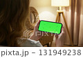 Woman use digital tech cell phone green screen mock up talk video call. Hand press click horizontal phone web site middle center. Girl hold mobile. Chroma key page. Cozy home background. Online app. 131949238