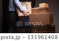 Man moving cardboard boxes during house relocation process 131961408