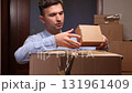 Man unpacking cardboard box delivery package at home 131961409