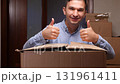 Happy man giving thumbs up from cardboard box 131961411