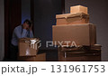 Stressed man coping with eviction paperwork and moving boxes 131961753